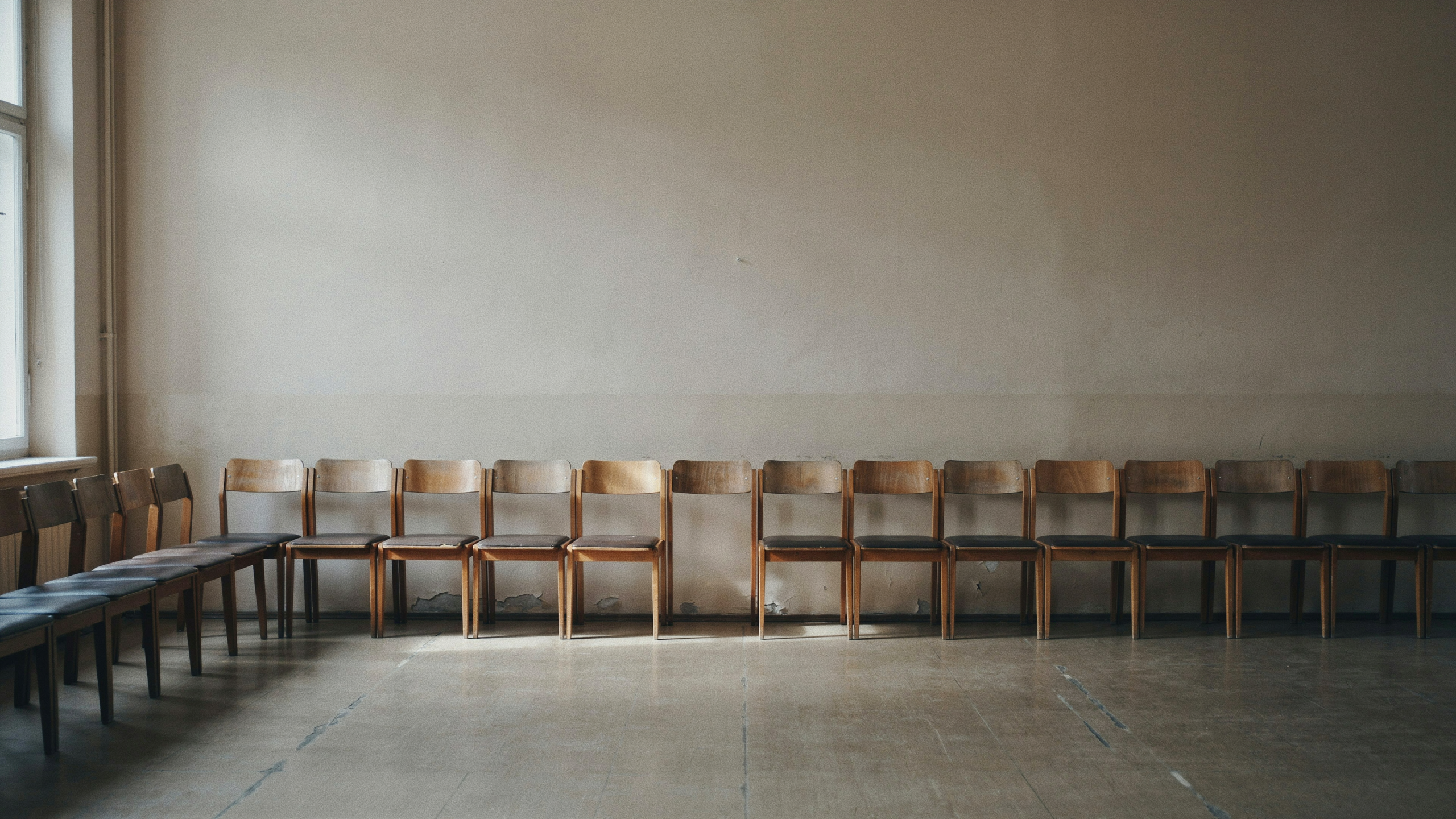 A row of identical empty chairs with one missing, illustrating survivorship bias
