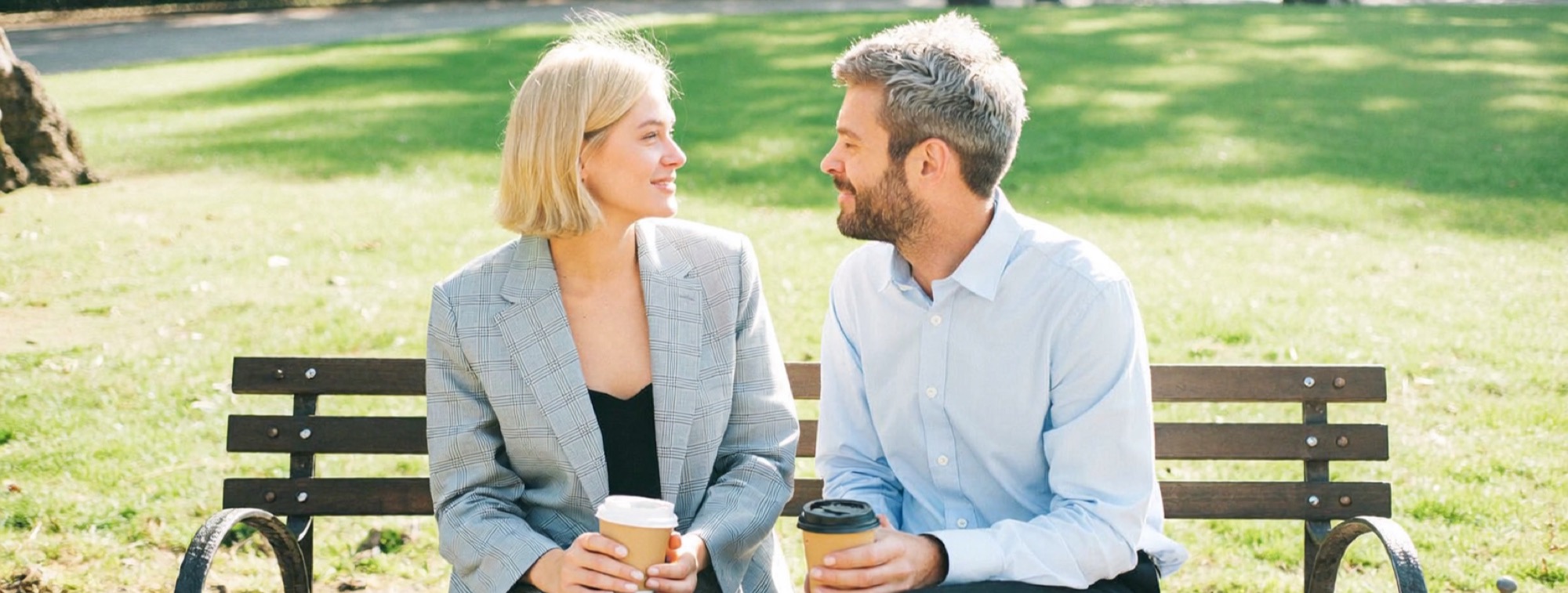 A founder talks through her first offer with a client on a park bench