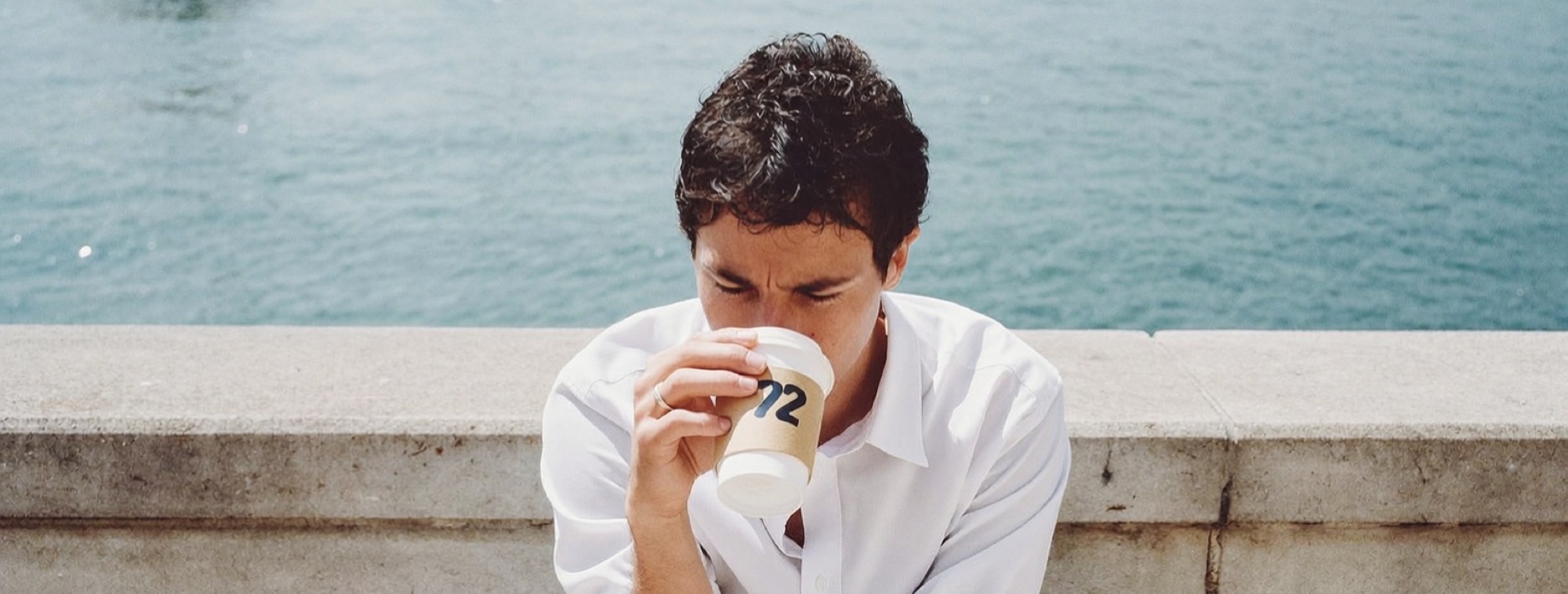 A founder on a waterfront wall with a coffee, working out what to charge