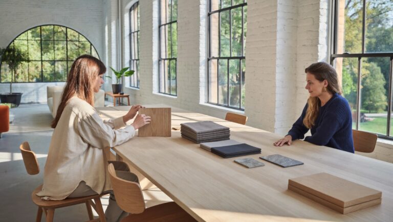 High-ticket offer: an interior architect in a private consultation with a client in a bright studio