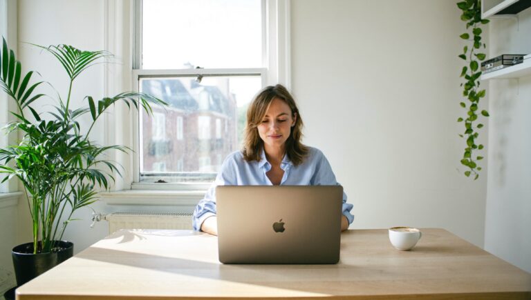 A woman working relaxed with her laptop in a bright sunlit room