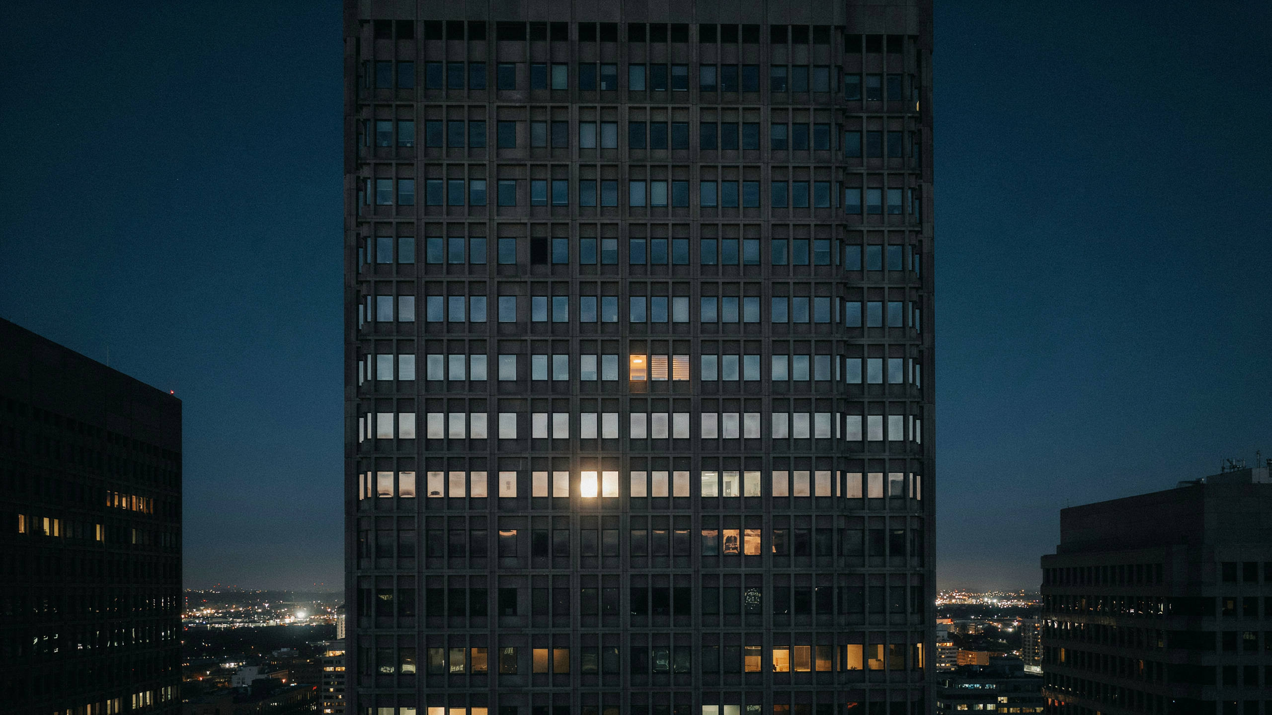One lit window in a dark office building, illustrating selection bias in what we notice