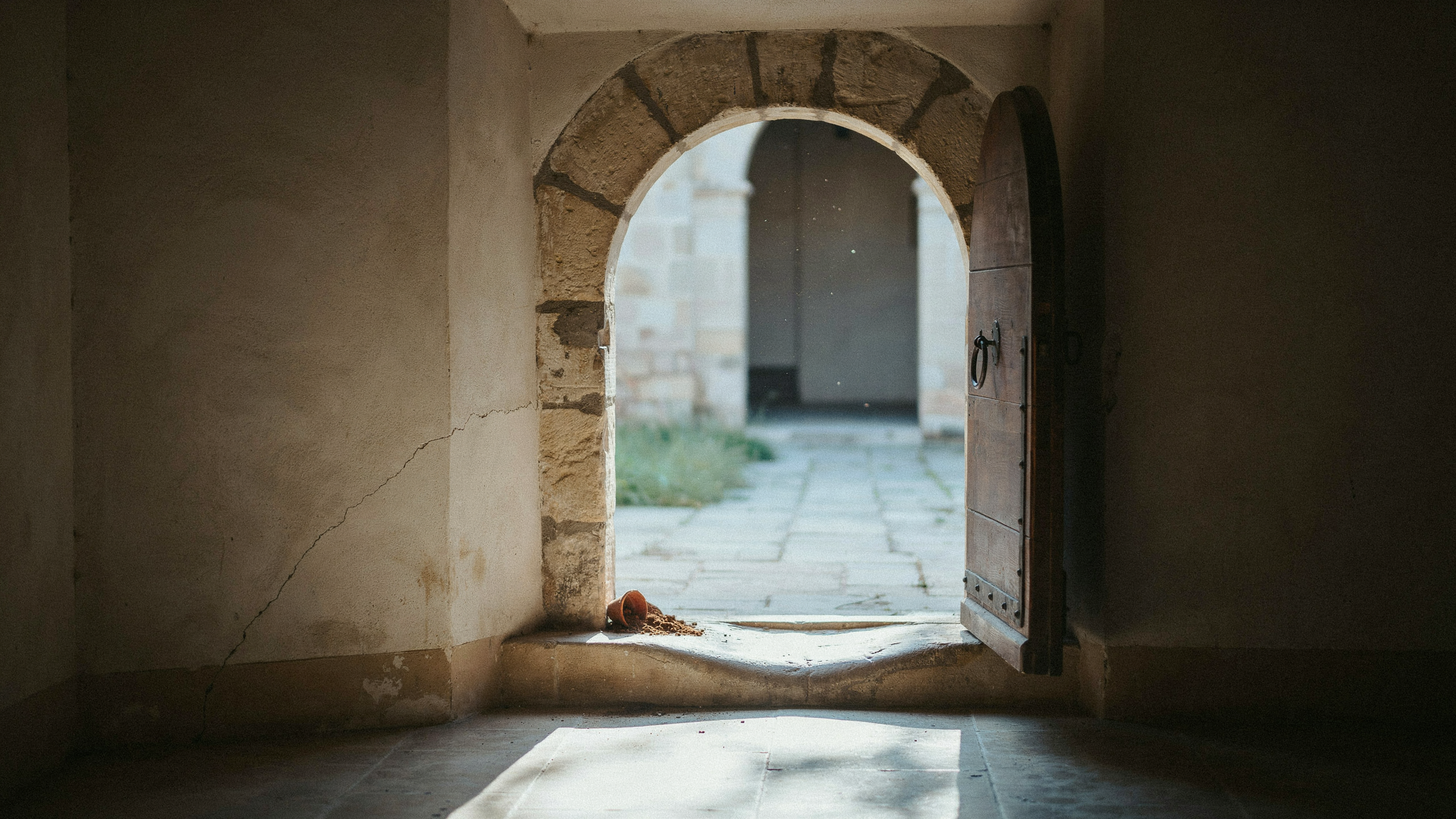 A low stone doorway with a worn threshold, illustrating a ceiling on growth