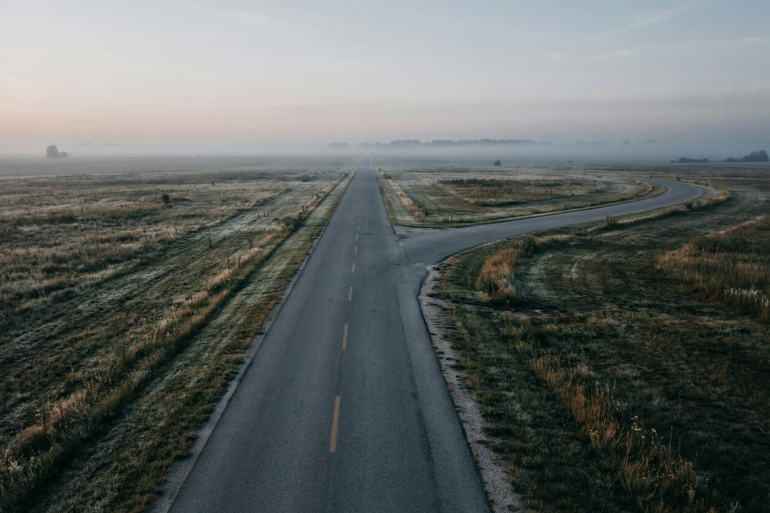 Two roads diverging, representing the decision to persist on one effort and abandon another