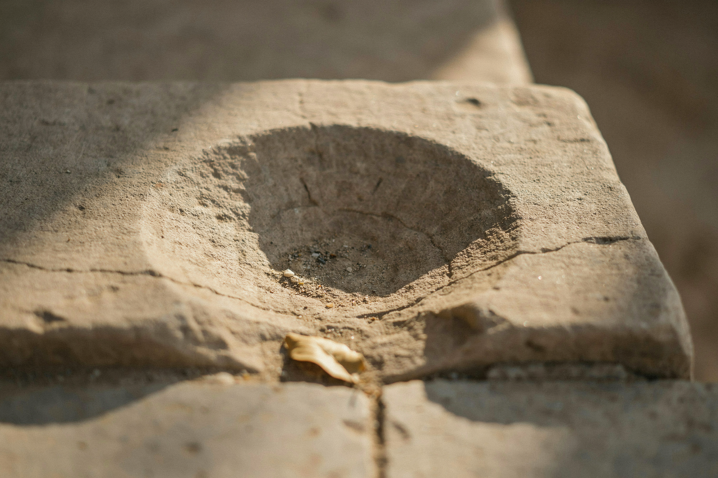 A stone step worn hollow over centuries, the slow effect of a cost you never see