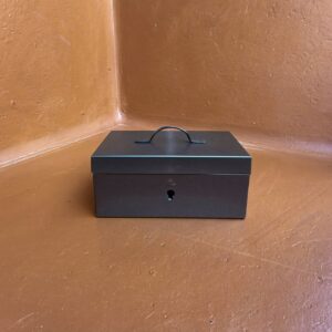 A small steel lockbox, closed, money put beyond easy reach on purpose