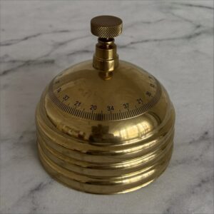 A single brass weight on white marble