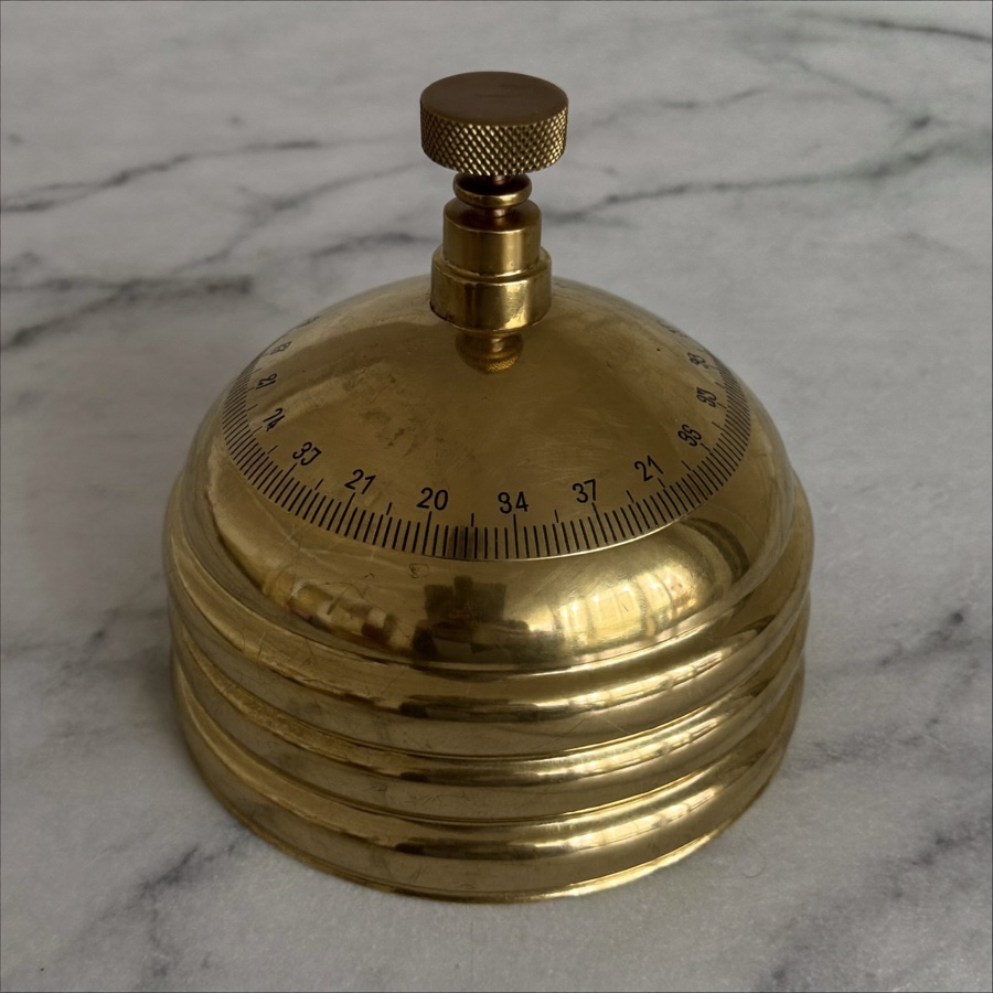 A single brass weight on white marble