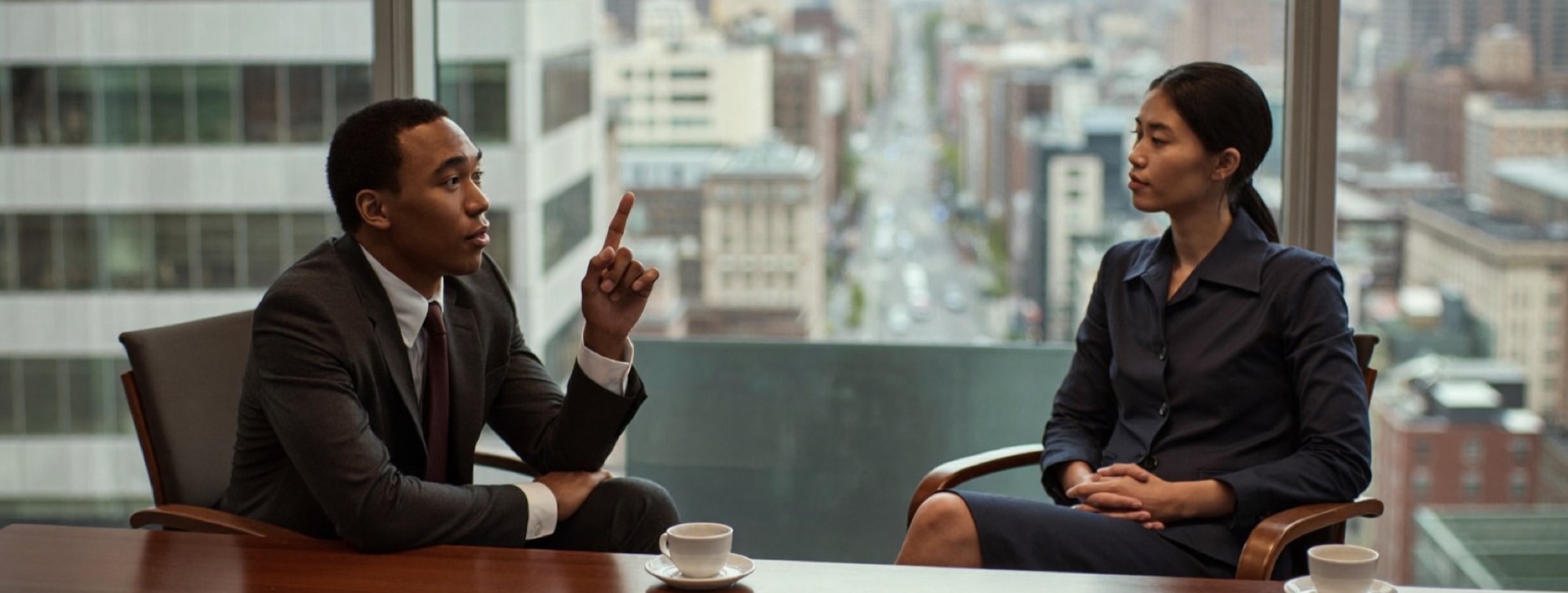 A client leaning forward with a raised finger while an executive sits back calmly