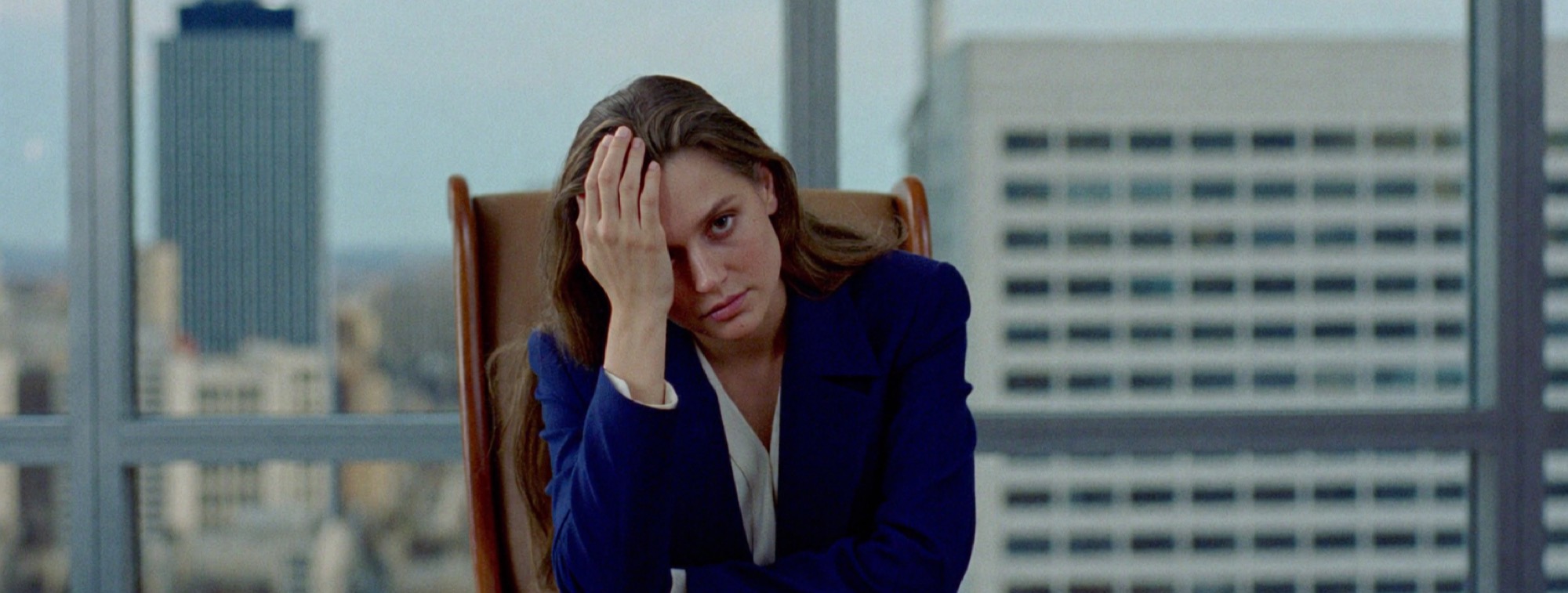 A woman alone at a meeting table after a difficult meeting