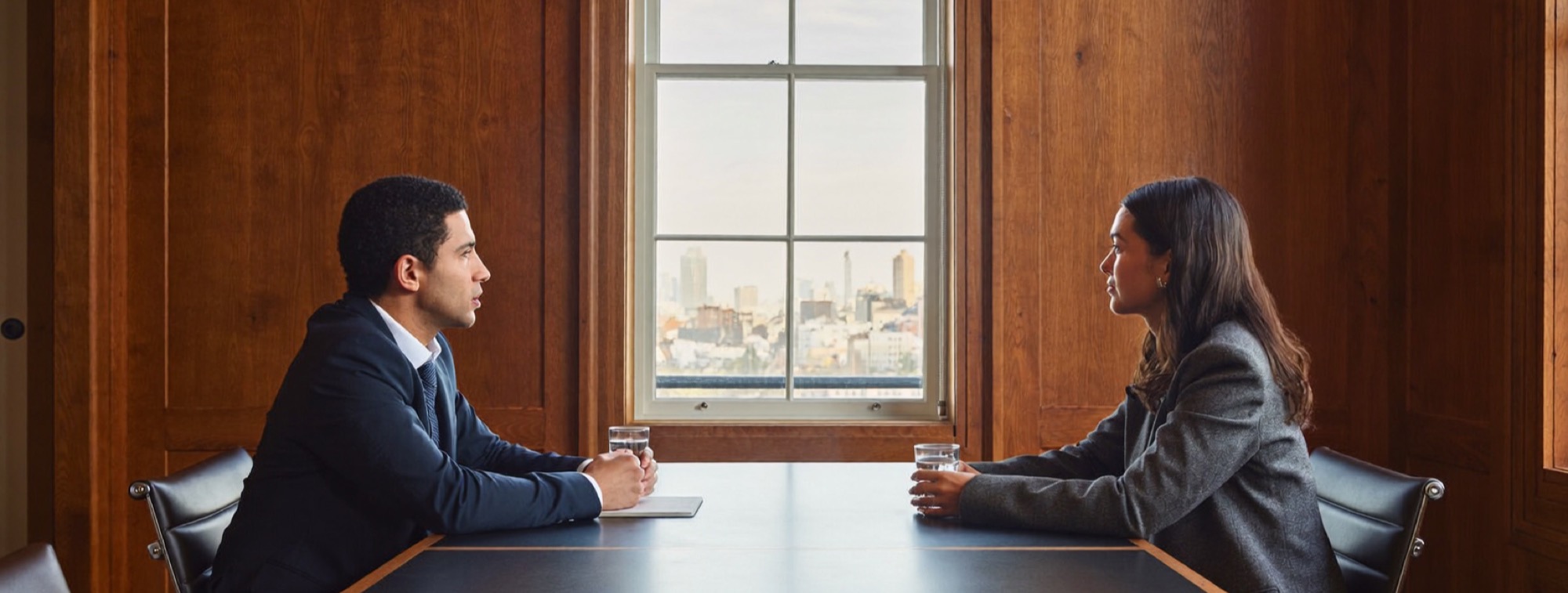 A financial adviser explains his fees to a client in his office
