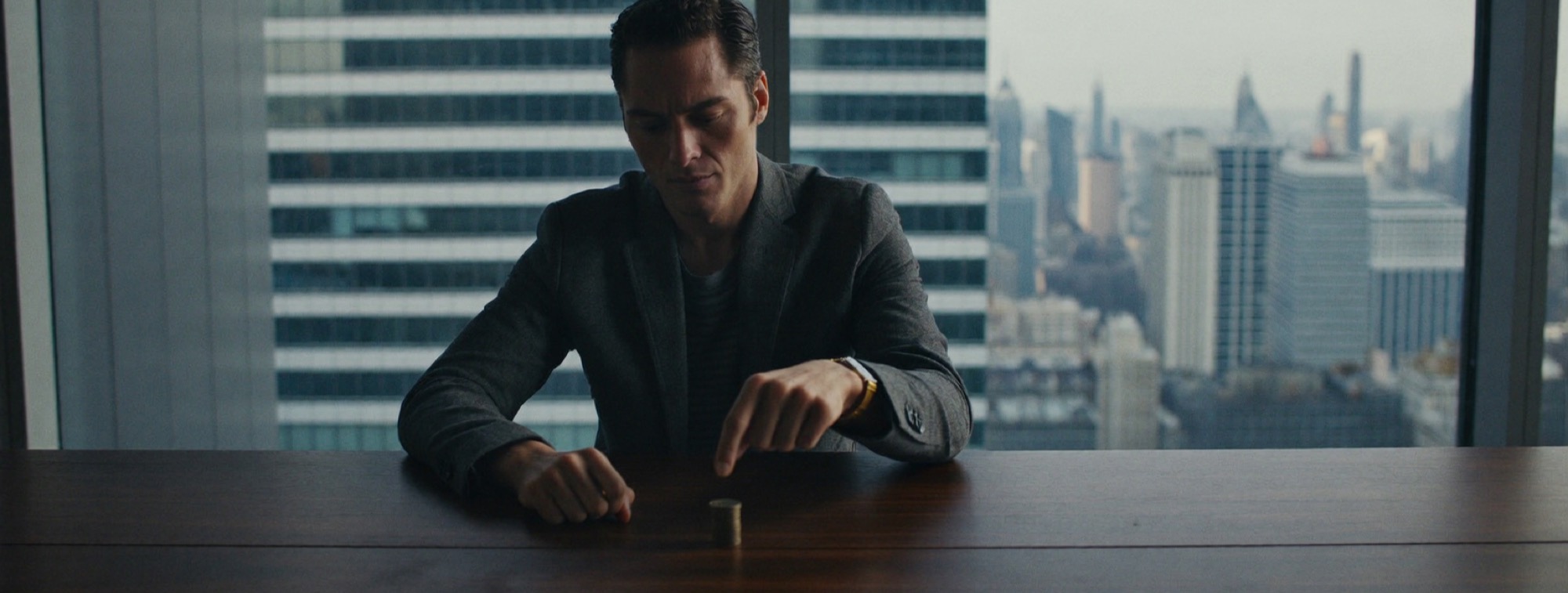 A man sliding a single coin off the top of a stack