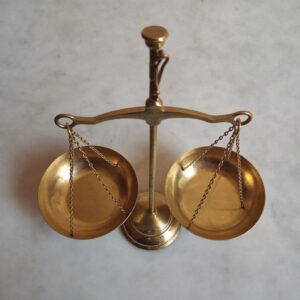 How much do financial advisors charge: a small brass balance scale, empty and level