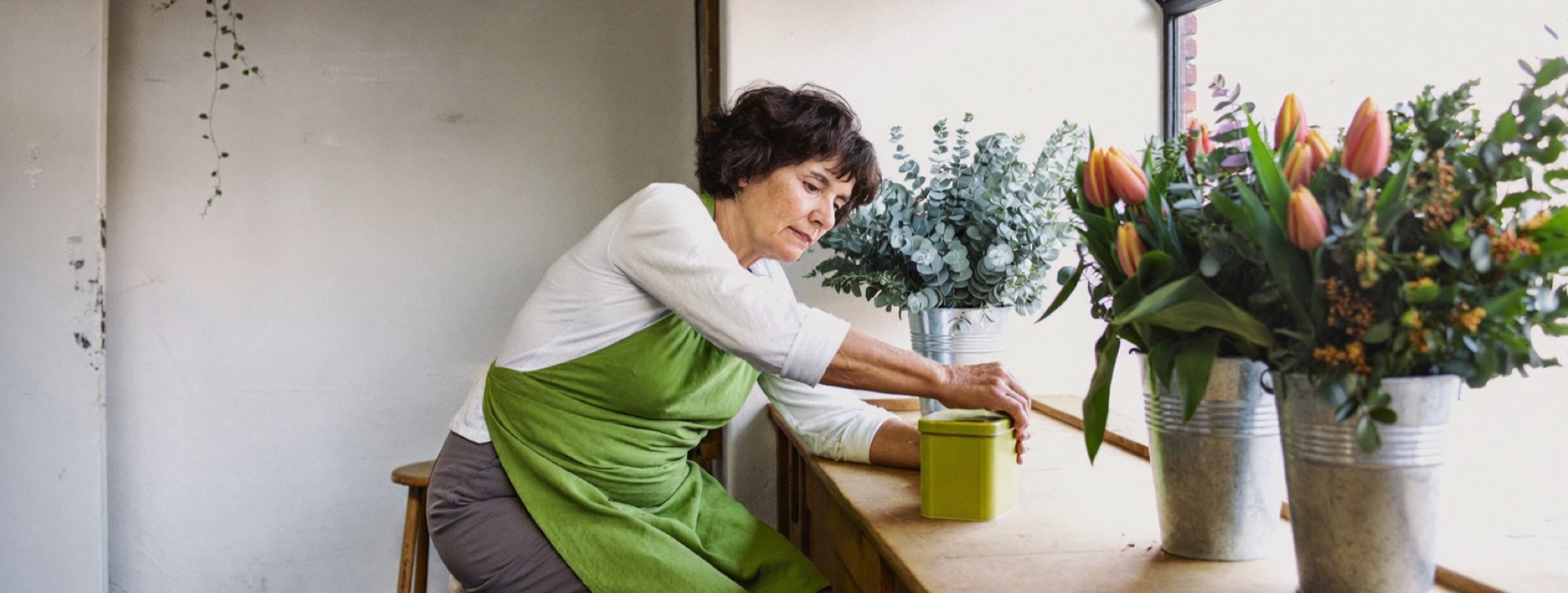 A florist setting money aside in a separate tin at her counter, the tax share kept apart