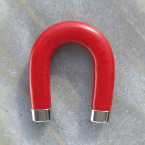 How to get your first clients: a red horseshoe magnet on pale grey stone