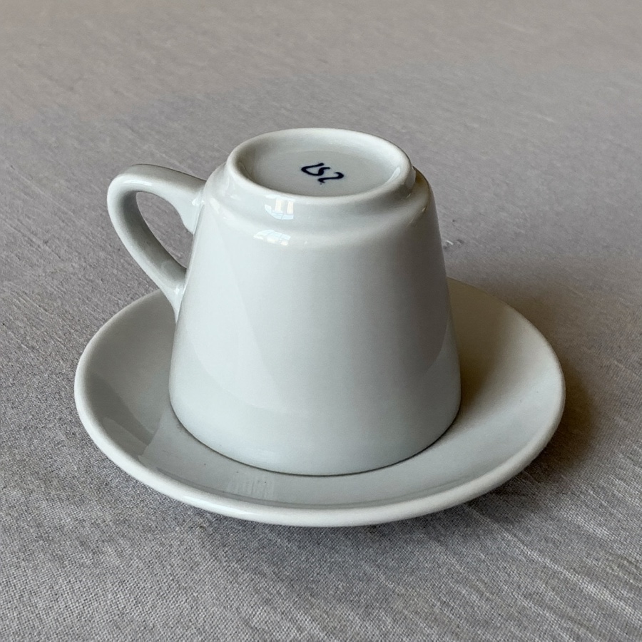 An espresso cup turned upside down on its saucer