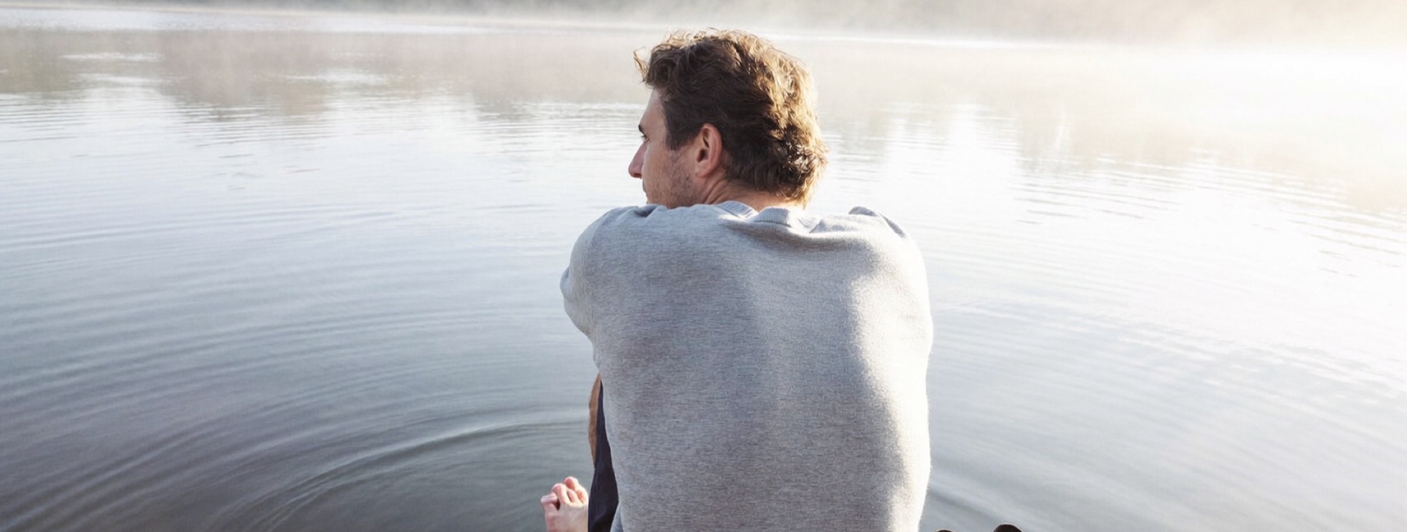 How to think 10x bigger without breaking: a founder resting at the end of a lakeside dock at sunrise