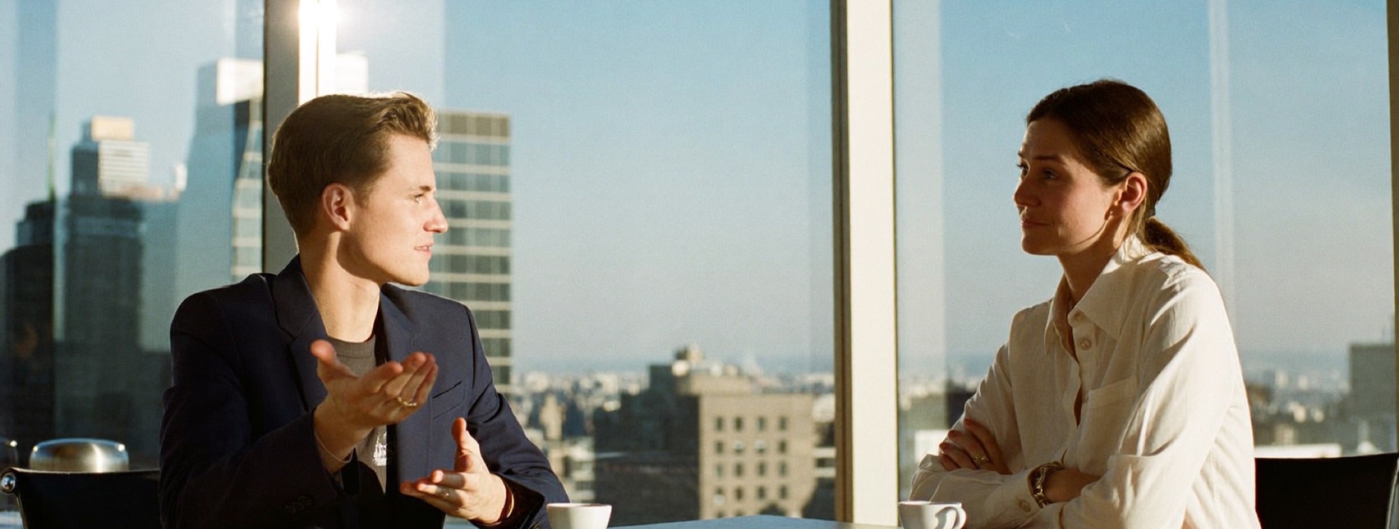 A founder explains his idea to a sceptical prospective customer across a meeting table