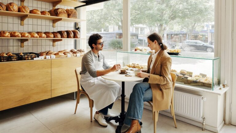 How to value a small business: a baker and a prospective buyer at a table in the bakery before opening