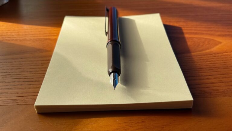 A fountain pen resting on a blank notepad in morning light, where writing better starts