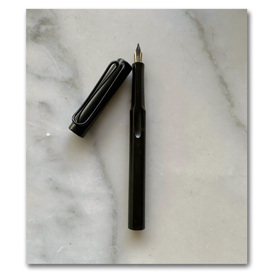 How to write with AI: an uncapped black fountain pen on white marble