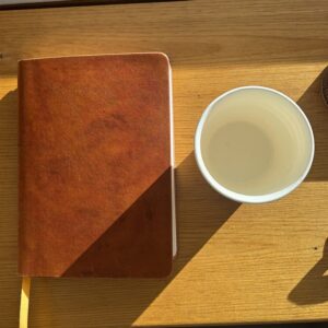 A closed notebook and cup on a desk, a day with limits set on it
