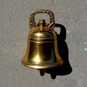 A small bell on a bare surface, a signal that someone is willing to pay