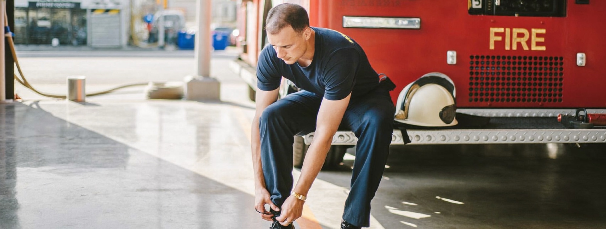A firefighter lacing his boots in a bright fire station, the kind of expert Gary Klein studied