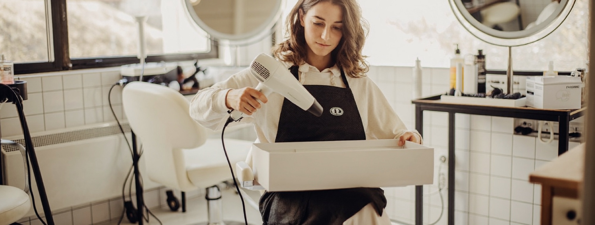 A salon owner unpacking new equipment, the money reinvested instead of paid out