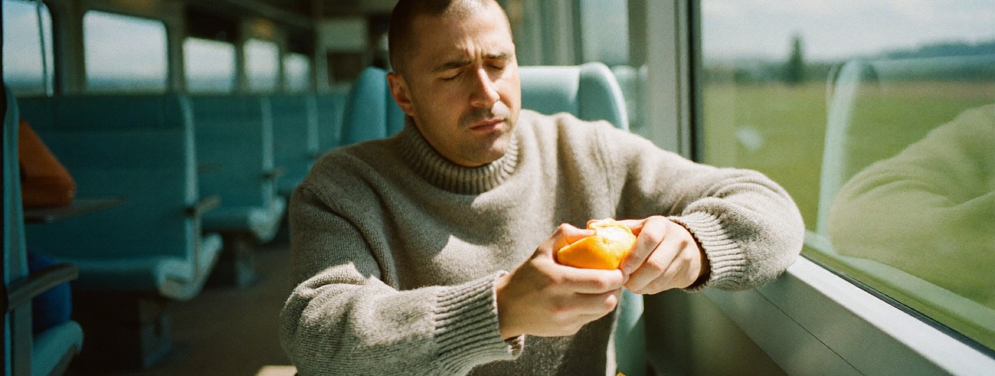 A man on a weekday train with nothing on the table in front of him