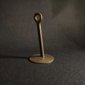 A single brass weight on a dark surface, weighing the cost of advice against what it delivers