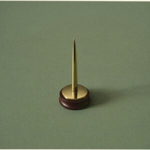 A brass bill spike, the old-fashioned tool for keeping receipts in order