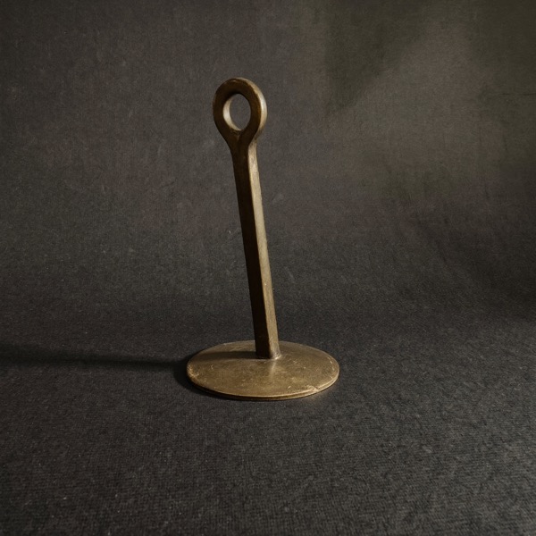 A single brass weight on a dark surface, weighing the cost of advice against what it delivers