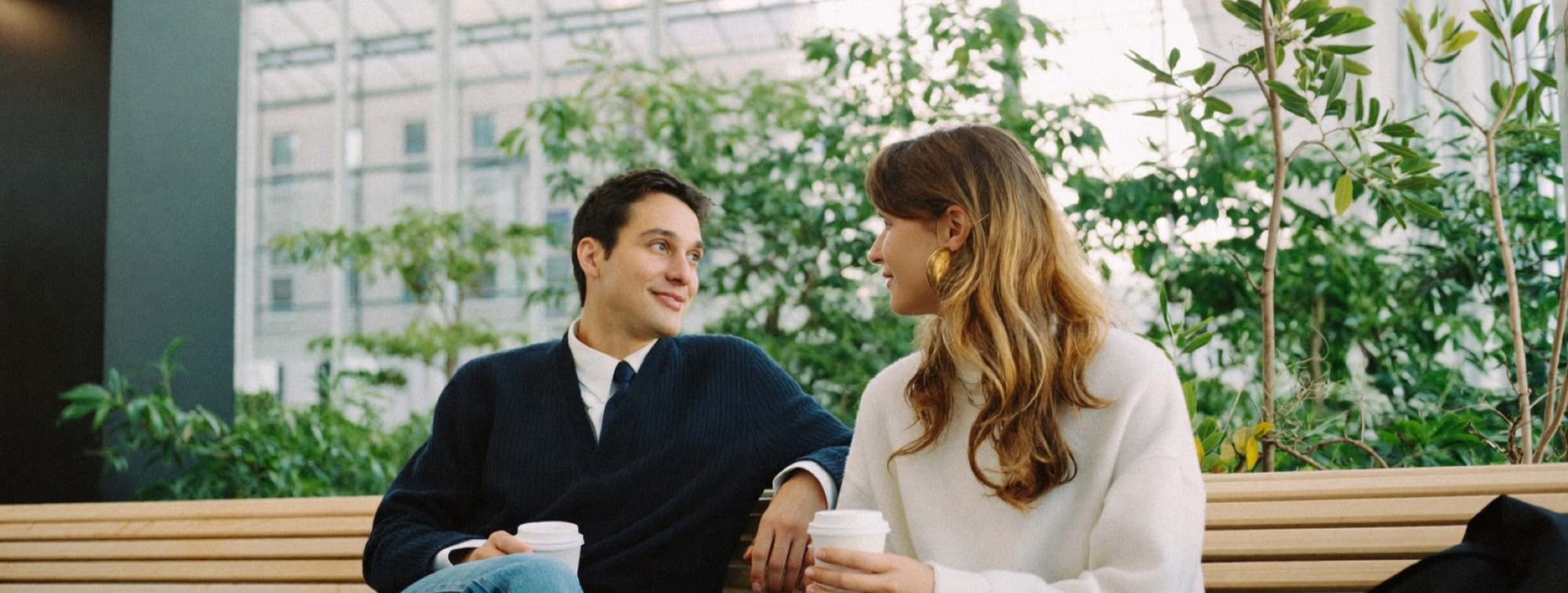 Two co-founders talking a decision through on a bench in a bright atrium