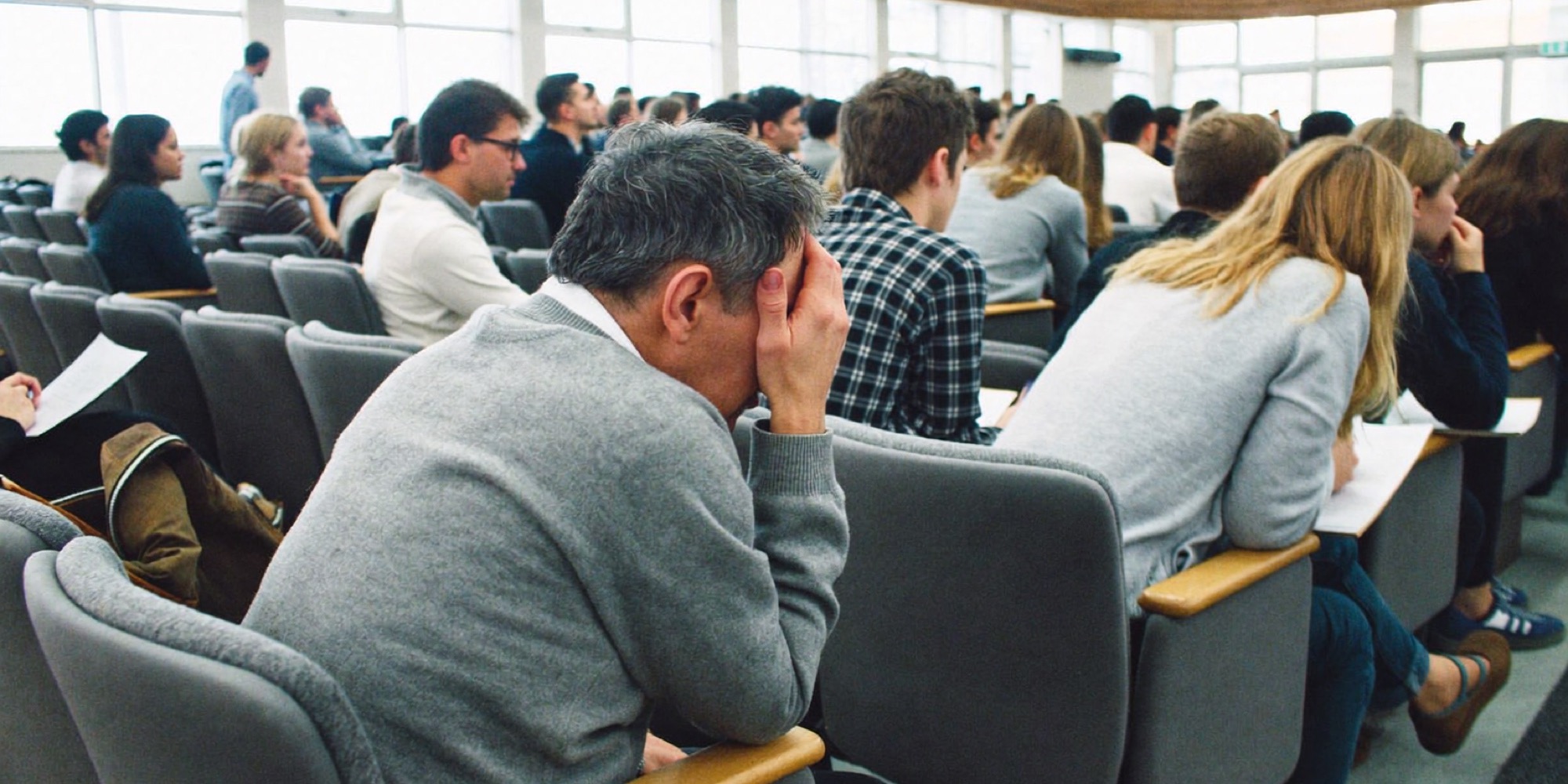 A man in his forties back in a business school lecture among younger students