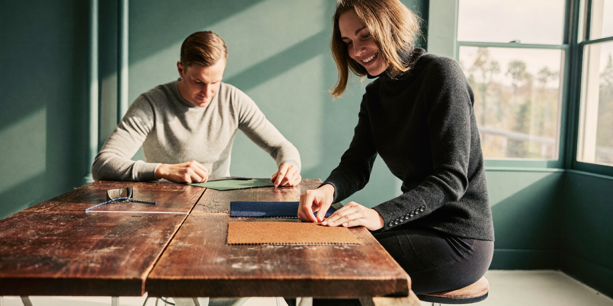 A founder choosing between two fabrics, one of many small decisions in a working day