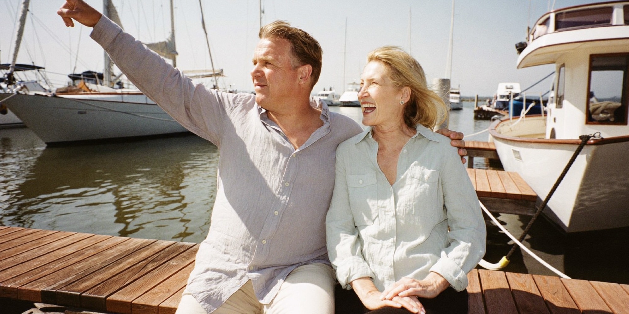 A couple on a marina bench picturing retirement before paying for advice