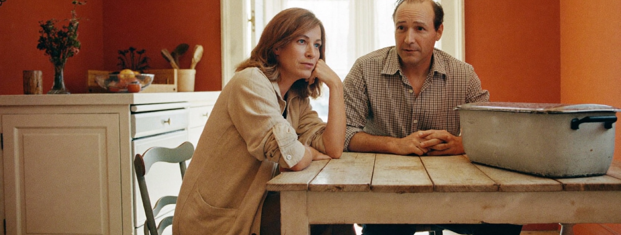 A couple talking over breakfast at a kitchen table, planning a return to work after burnout