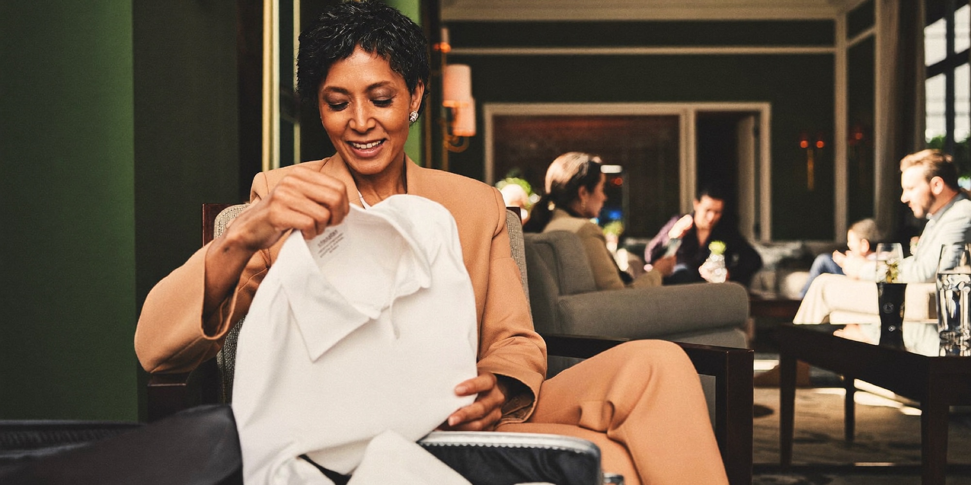 A traveller unpacking a folded shirt that survived the trip
