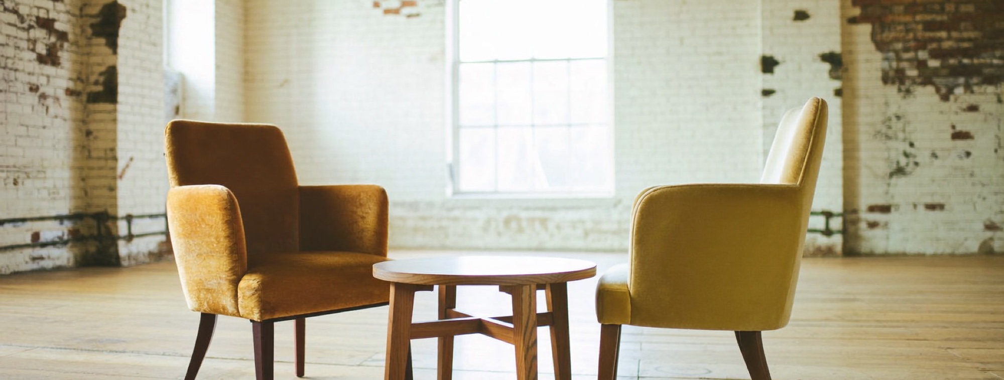Two chairs across a small table, set for the conversation before you hire an adviser