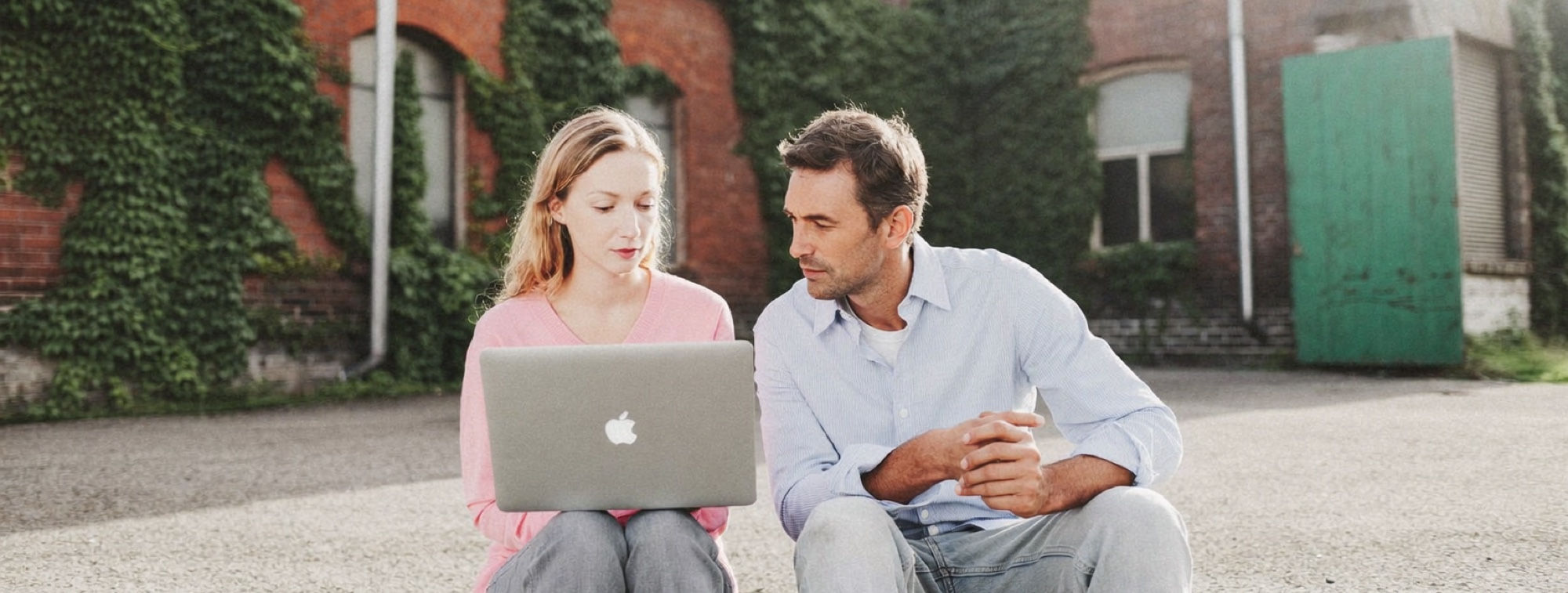 Two researchers comparing an AI answer with its original source in a courtyard