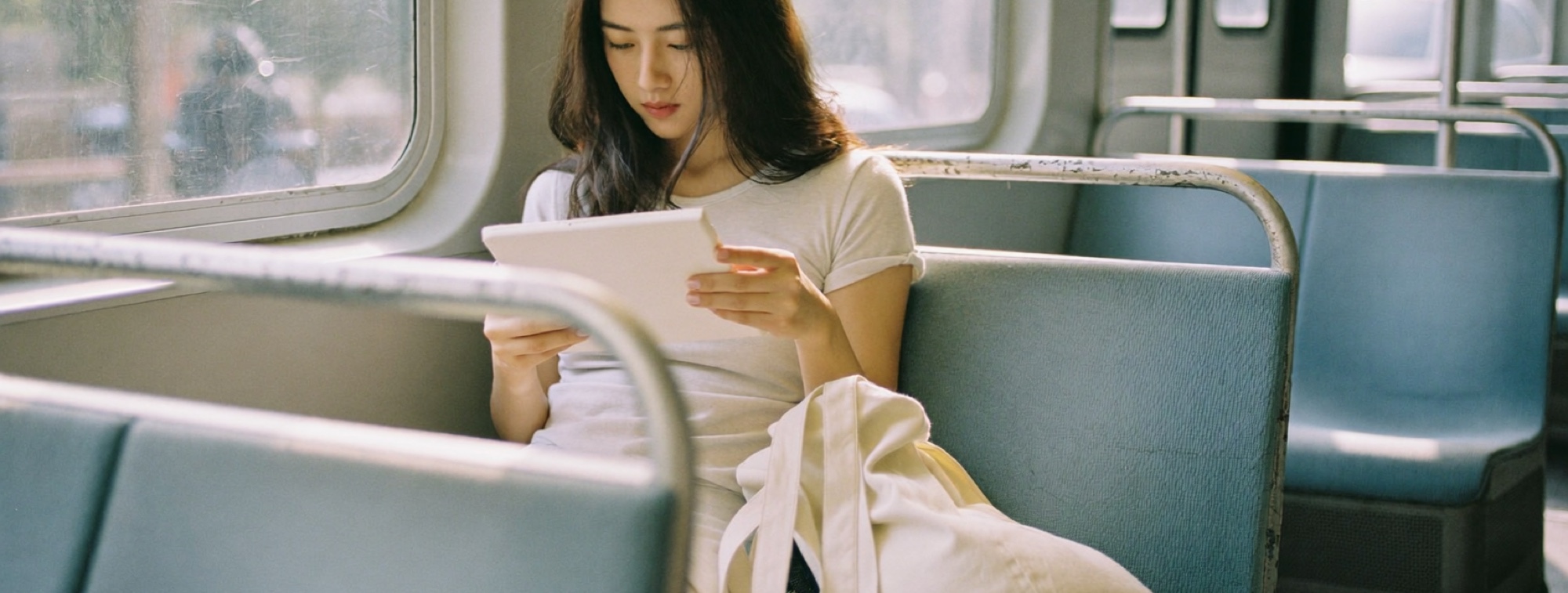 A commuter with an e-reader on the tram, reading in the gaps of the day