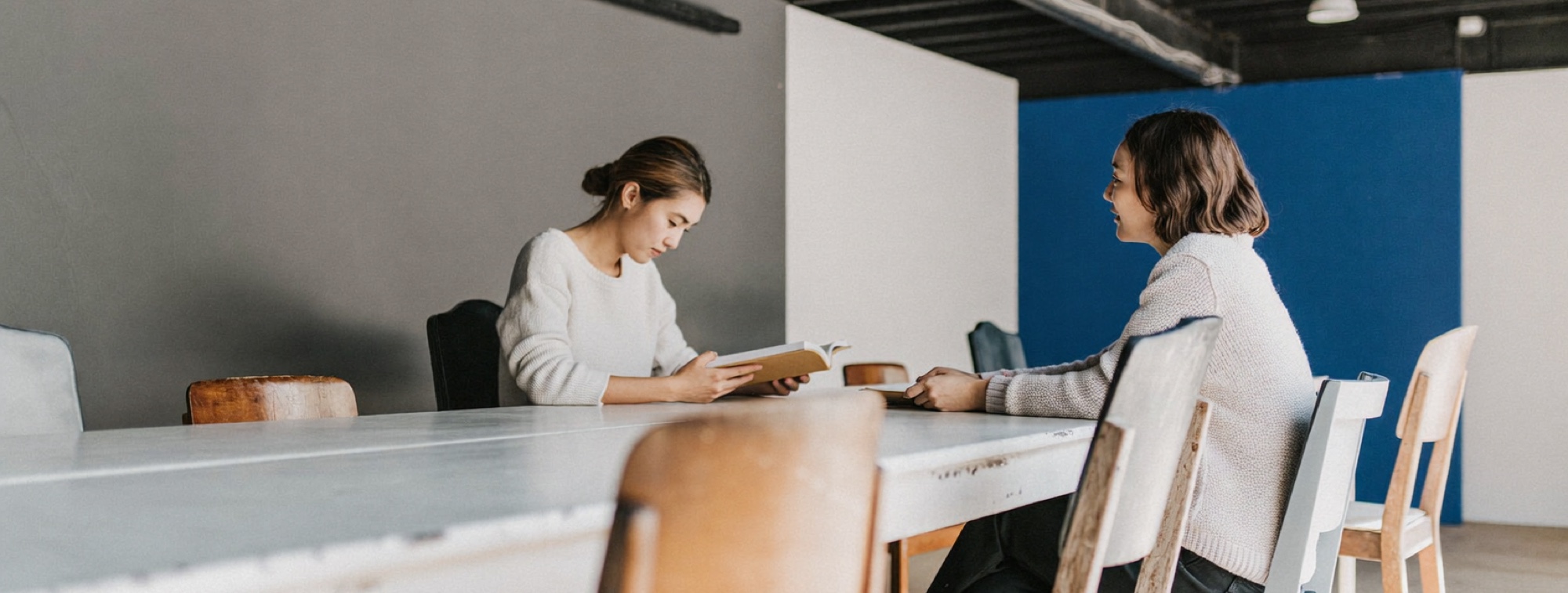 Two founders reading and talking through a chapter at a shared table