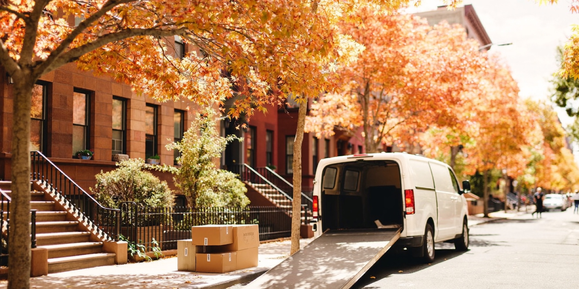 A removal van on a brownstone street in autumn, the kind of one-way move the regret minimization framework was used to make