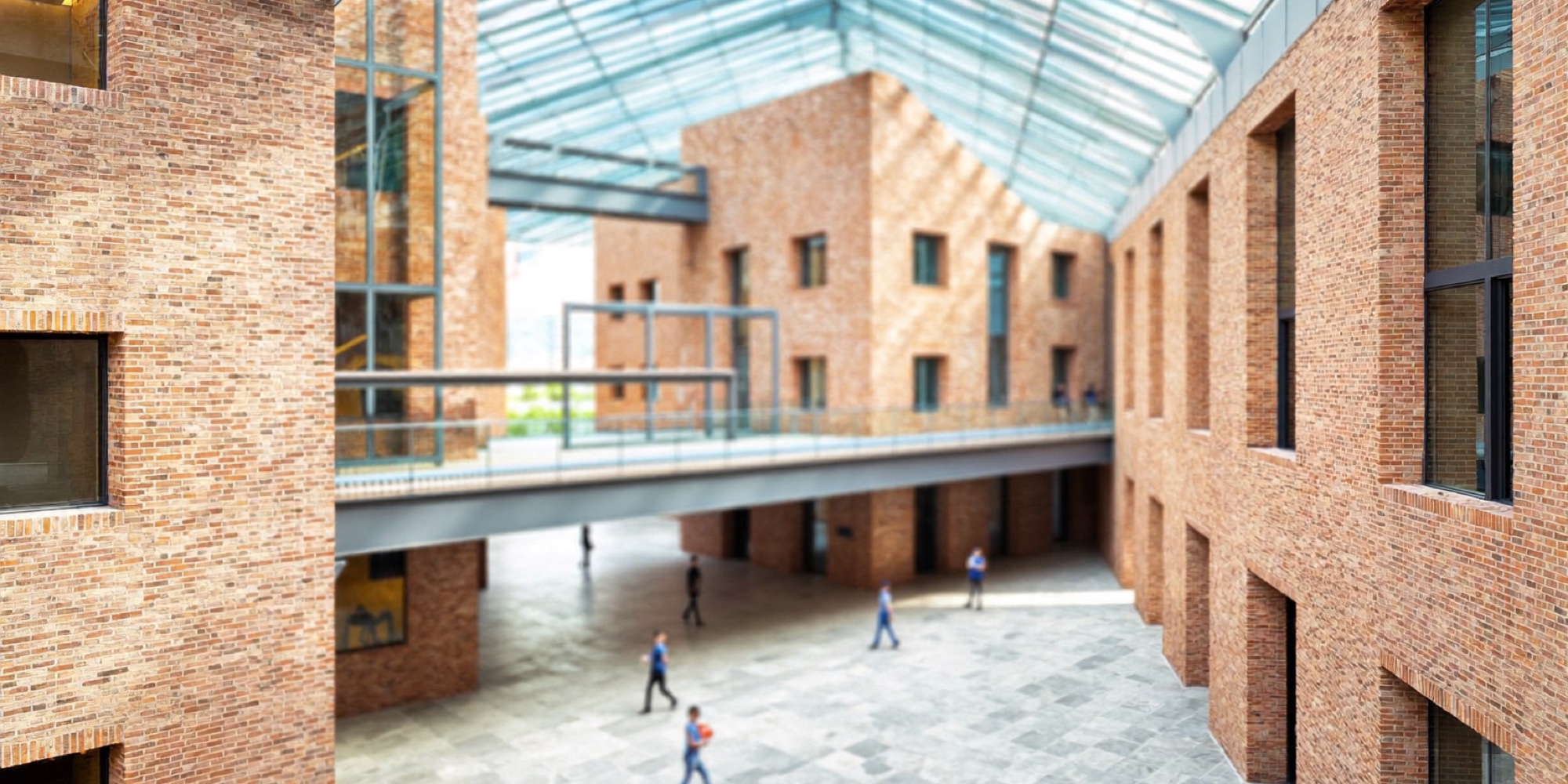 A bright brick and glass atrium, the kind of indoor light an office day offers once the morning has passed