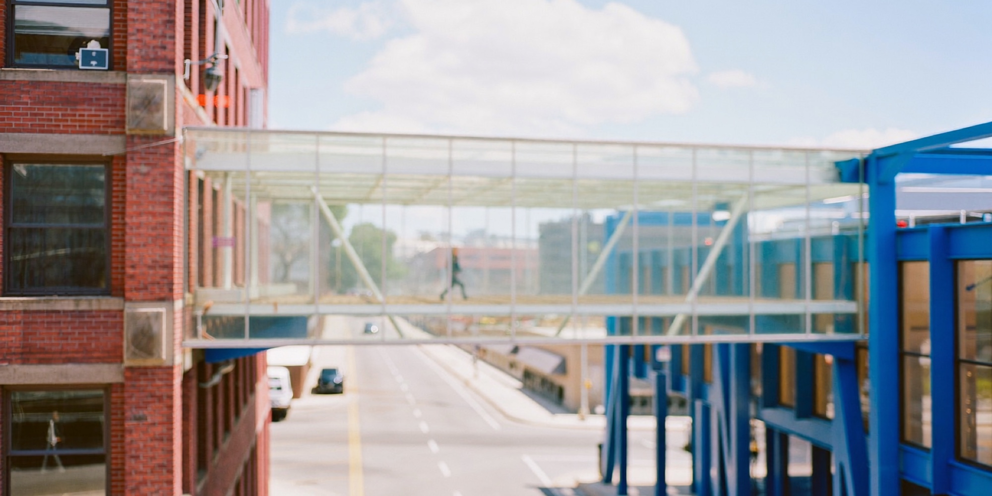 A footbridge joining two different buildings, the shape of a synthesis between two positions