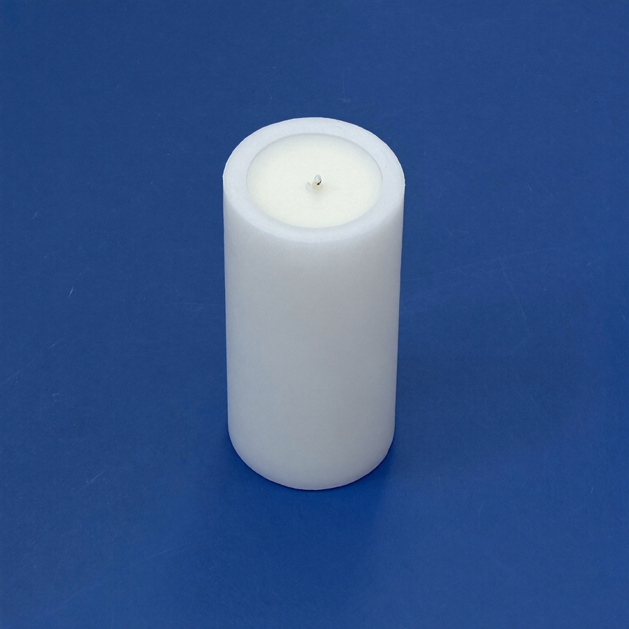 A single unlit white candle on blue plaster, a quiet moment in a working day