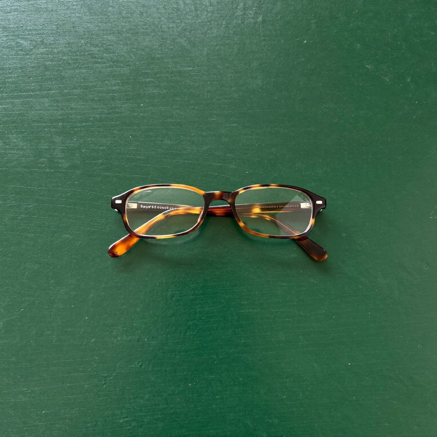 A pair of folded reading glasses, for the small print in an advisory agreement