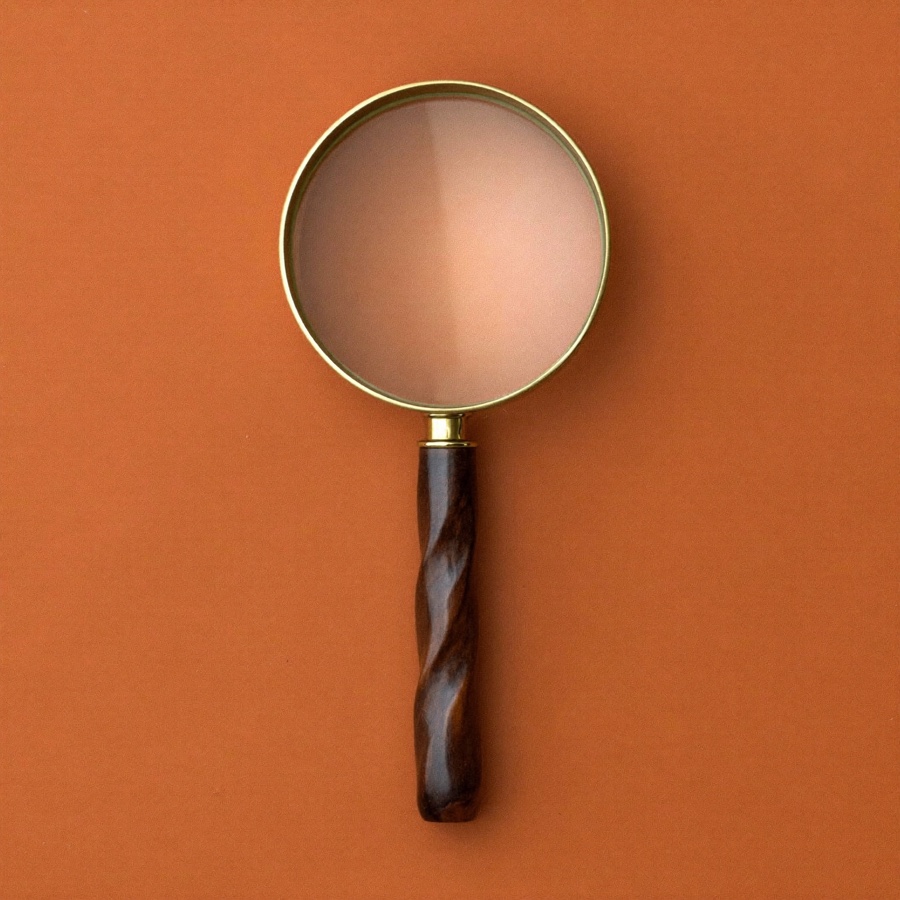 A brass magnifying glass, attention narrowed to one thing