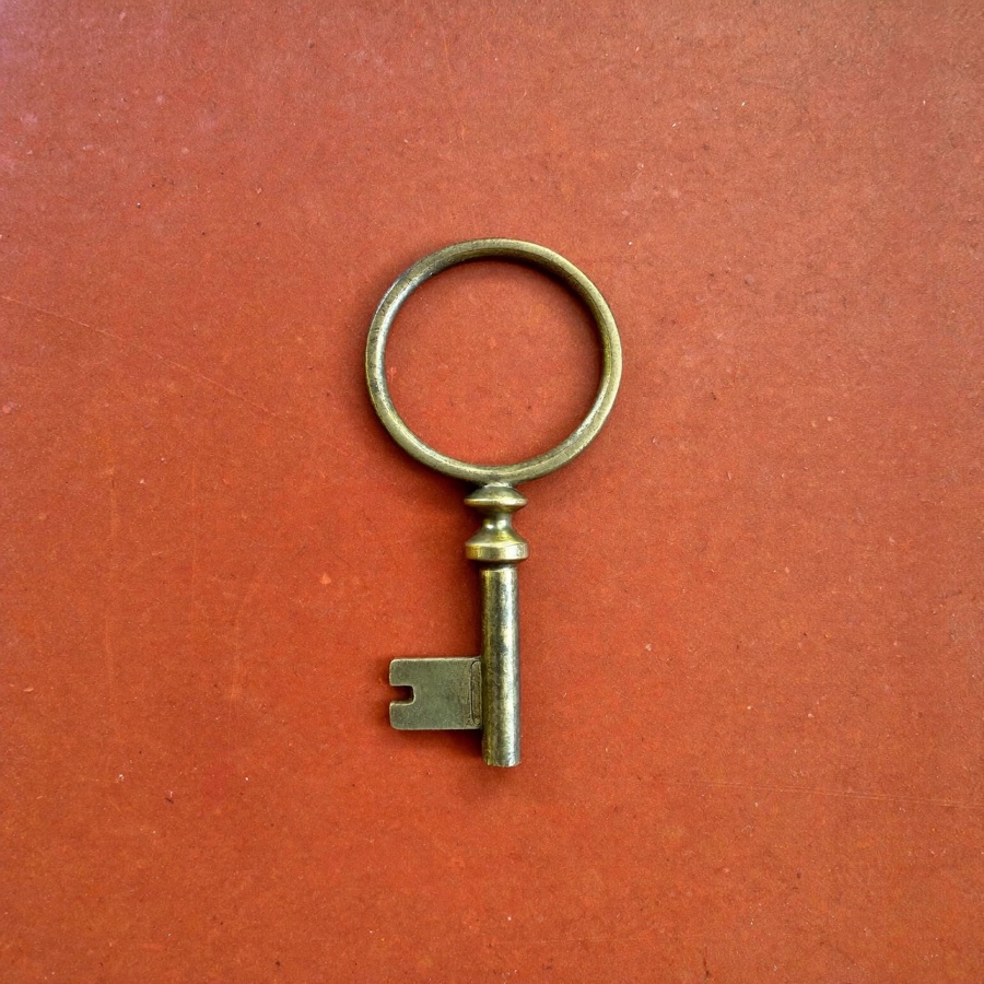 A brass door key, for locking the office door at the end of the day